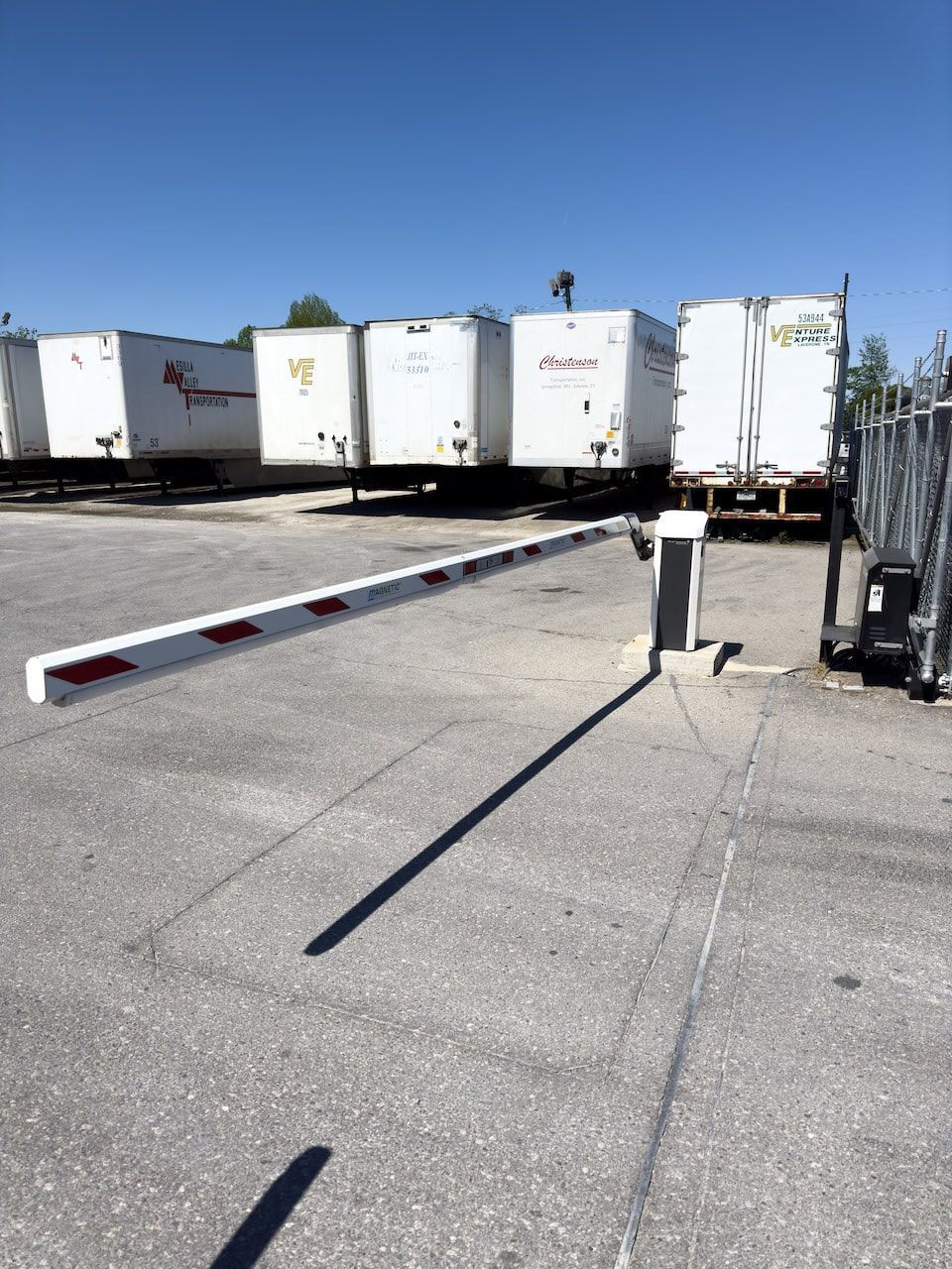 A row of white semi trucks are parked in a parking lot