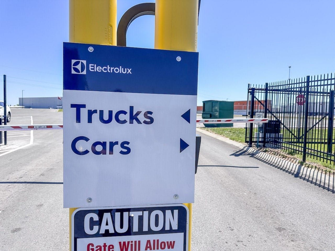 A sign that says trucks cars and caution gate will allow