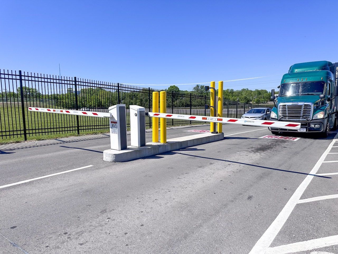 A green semi truck is driving through a parking lot