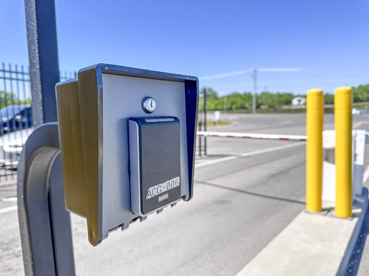 A close up of a key box on a pole next to a parking gate.