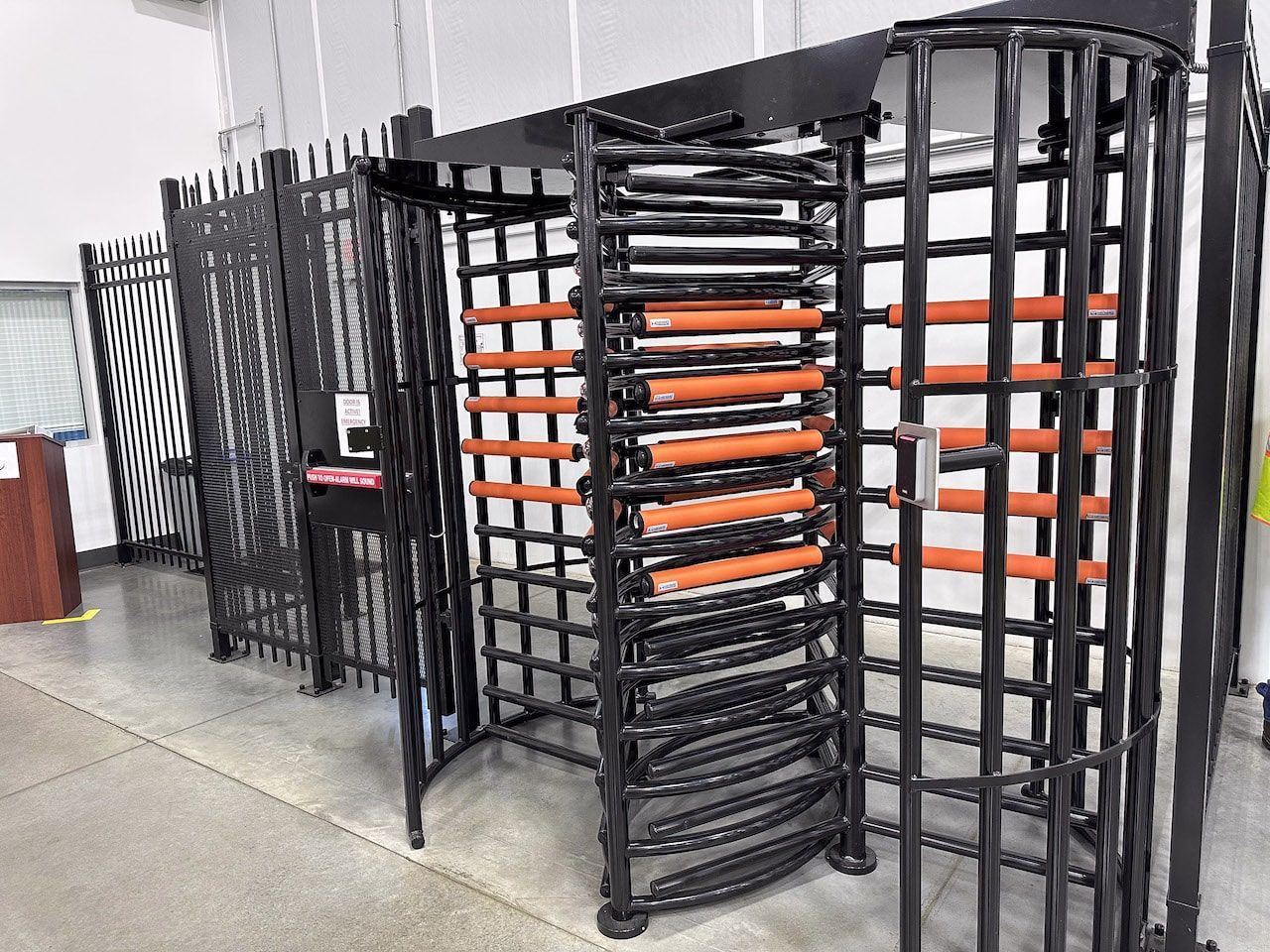 A row of turnstiles are lined up in a room.