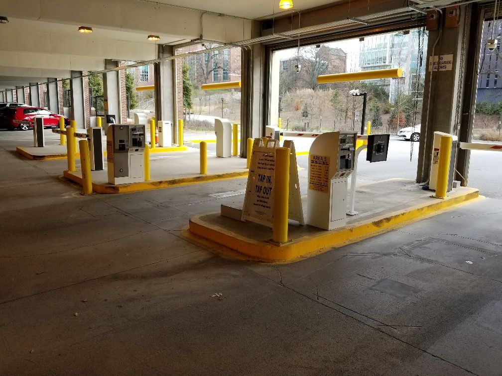 A parking garage with a lot of parking meters and a sign that says no parking.