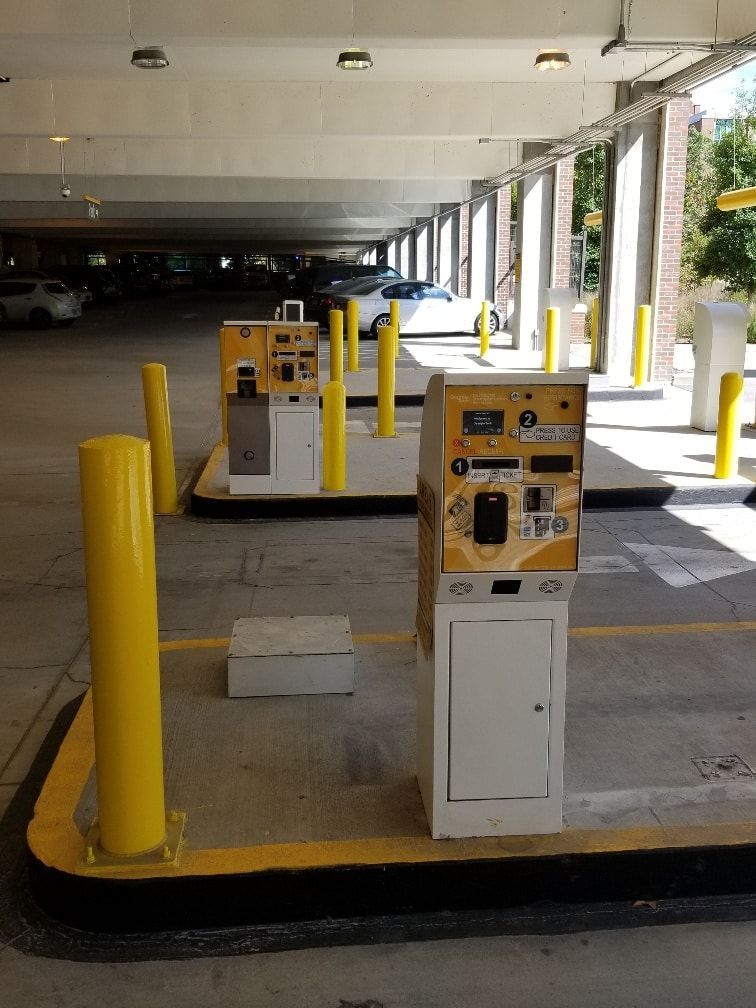 A parking garage with yellow poles and yellow barriers
