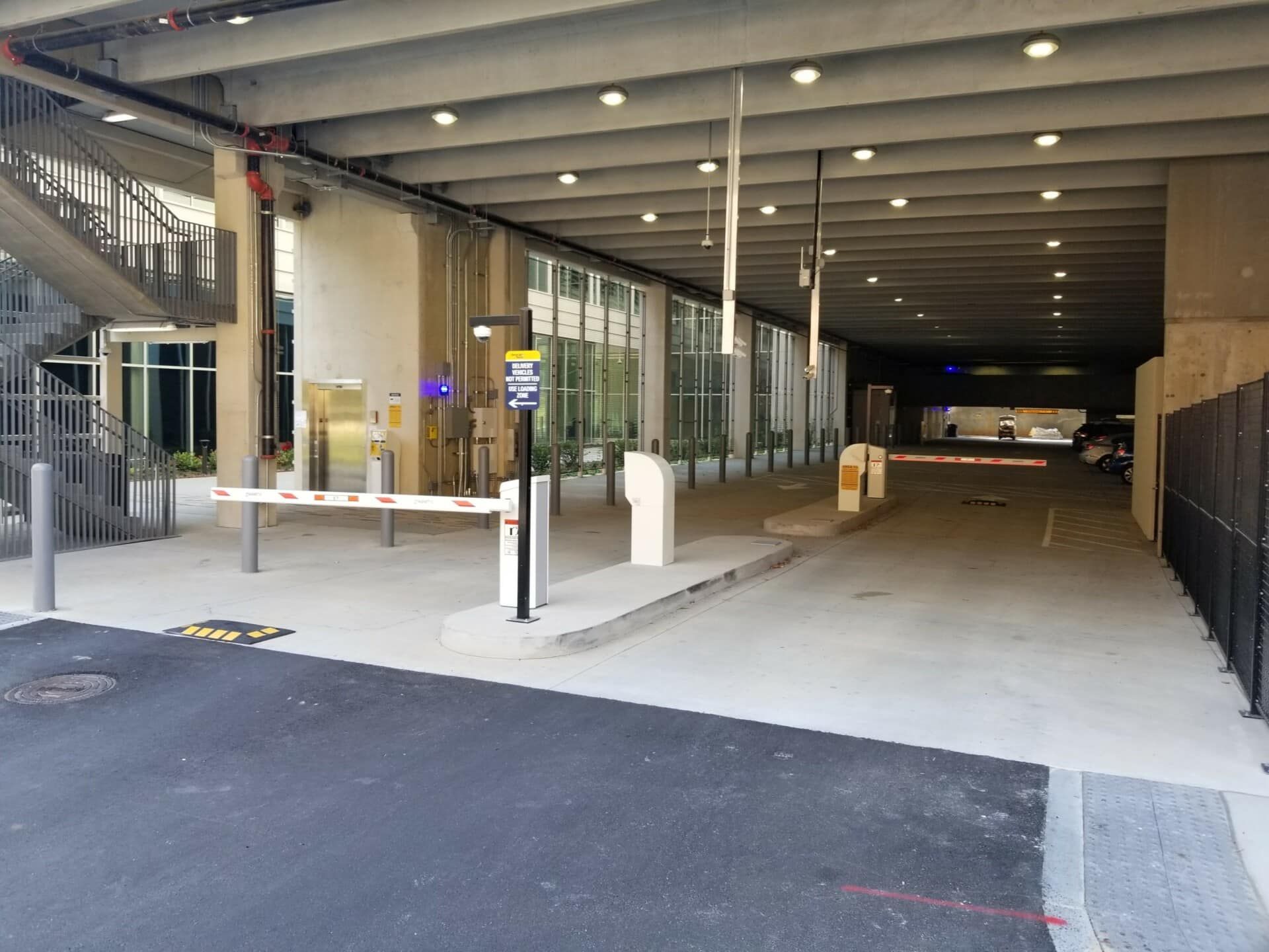 A parking garage with a barrier and stairs going into it