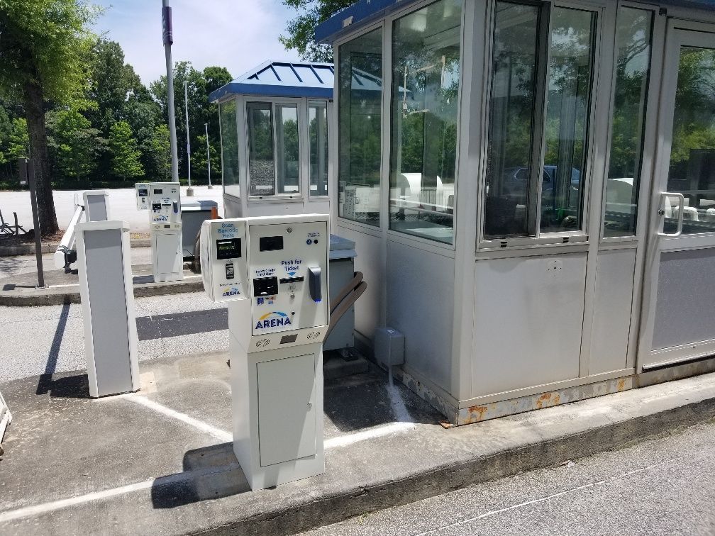A parking meter is sitting on the side of the road next to a building.