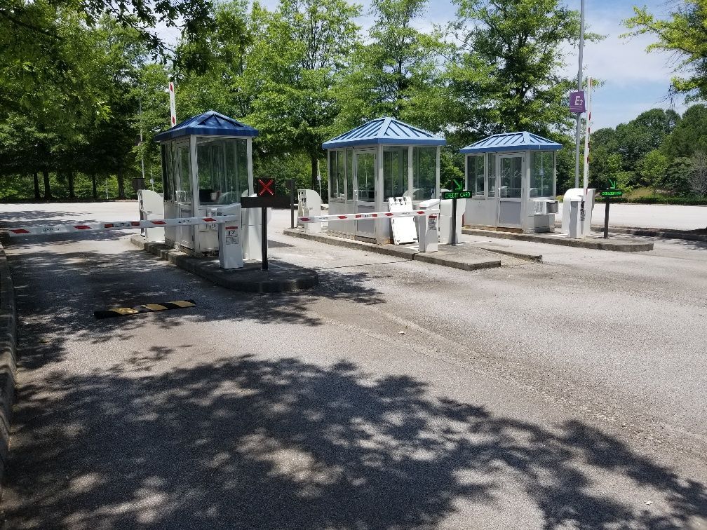 A parking lot with a row of booths and trees in the background.