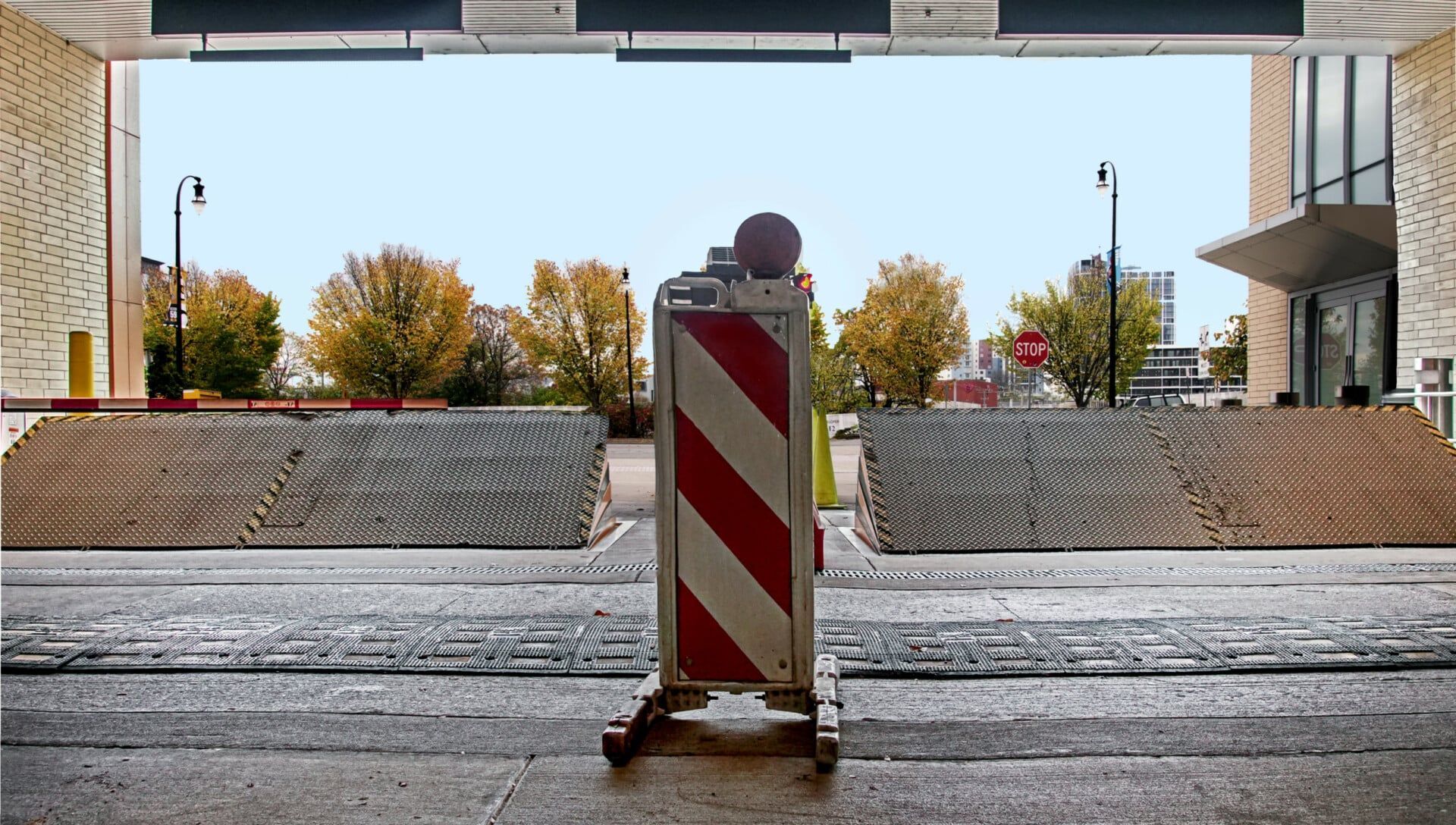 A red and white striped barrier is in the middle of a road