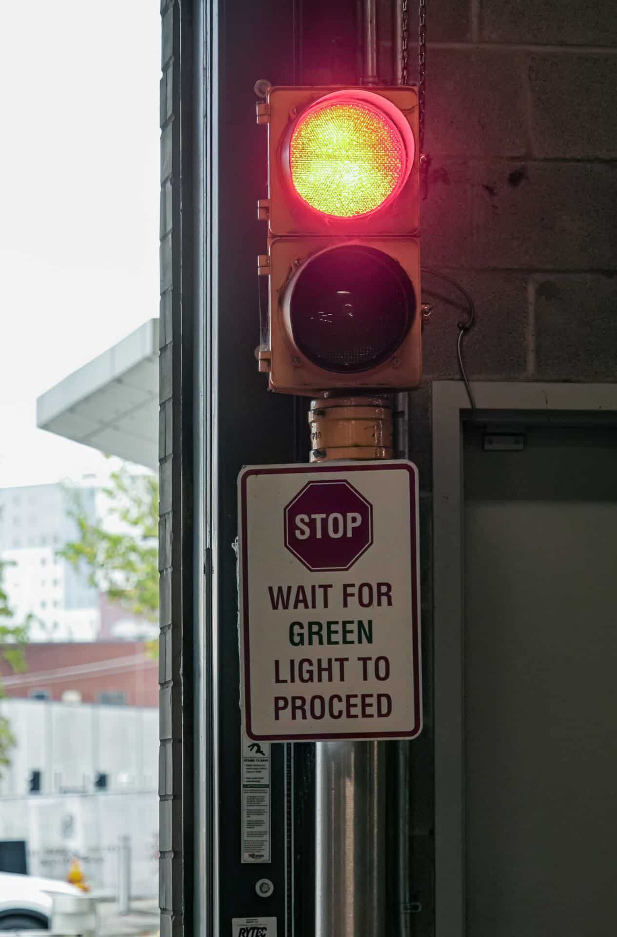 A stop sign is next to a red traffic light.