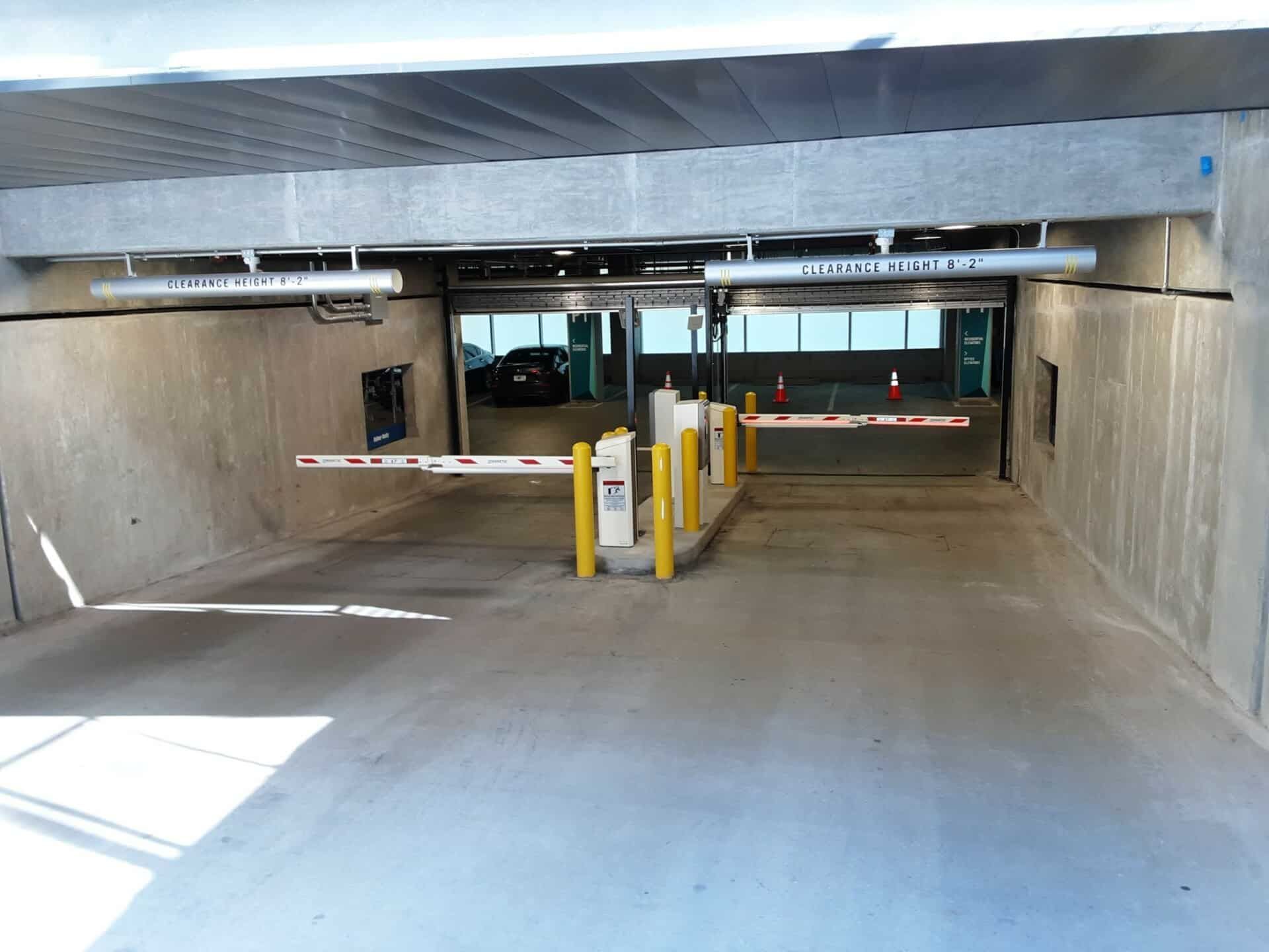 A parking garage with a barrier and a car in it