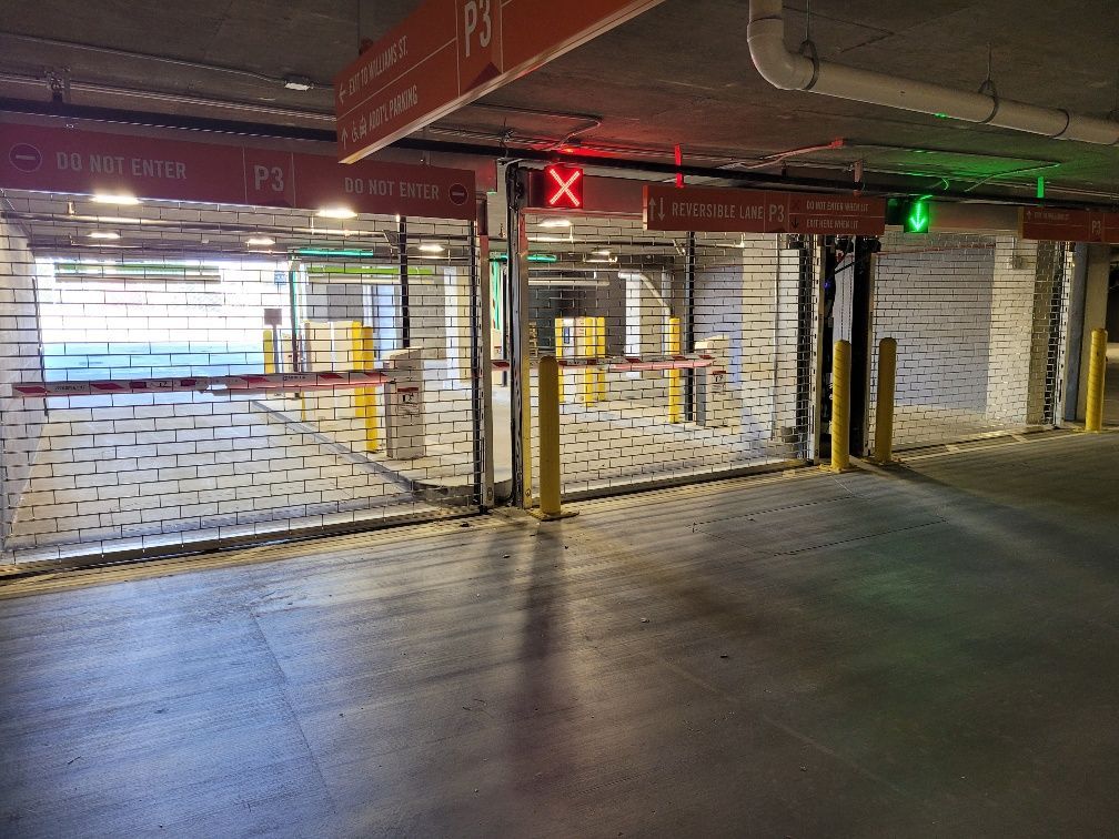 An empty parking garage with a red and green light.