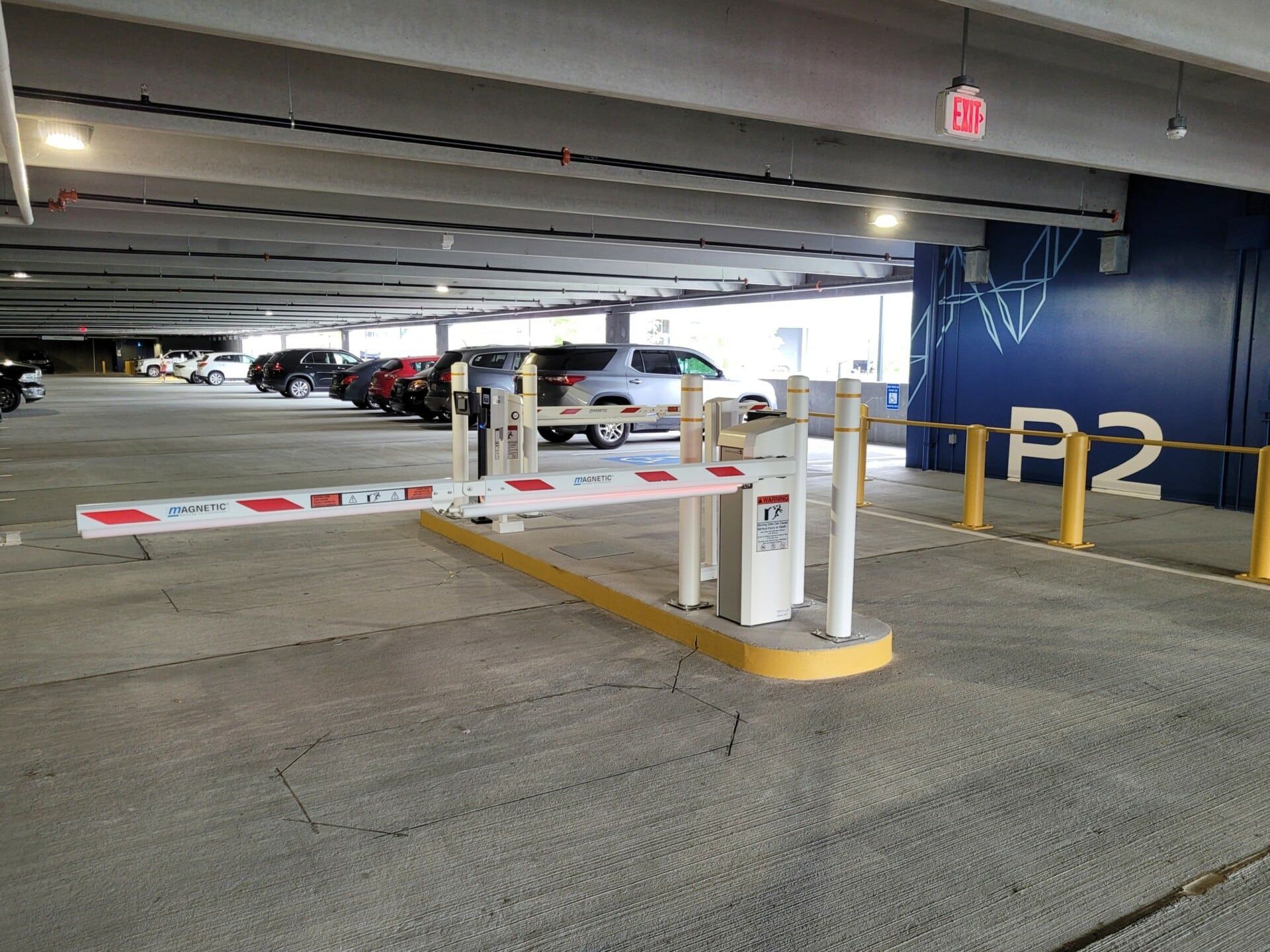 A parking garage with cars parked in it and a barrier.