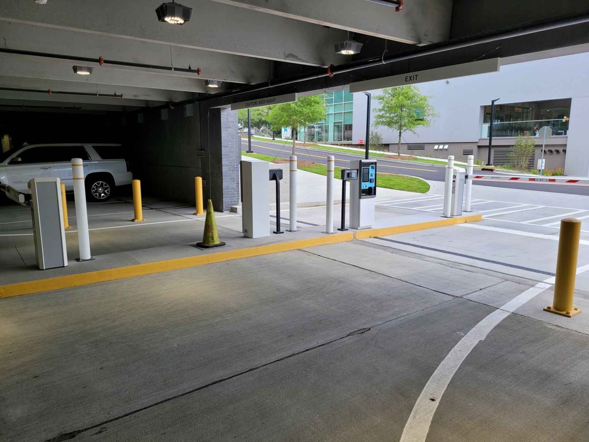 A car is parked in a parking garage next to a street.