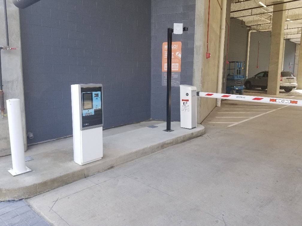 A parking lot with a barrier and a machine.