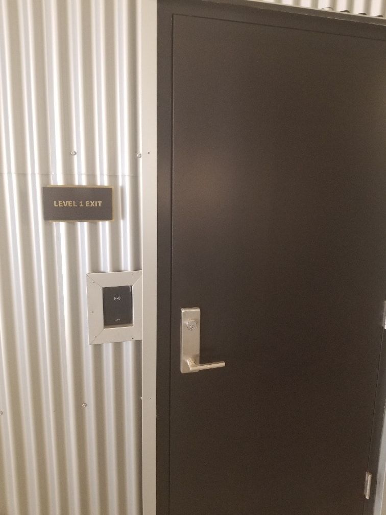 A black door with a sign on the wall that says level 1 loft