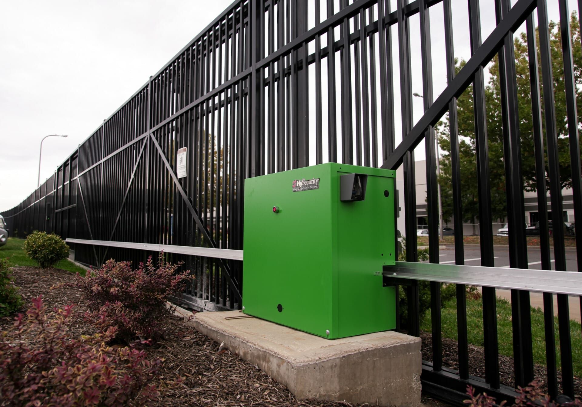 A green box is attached to a black fence