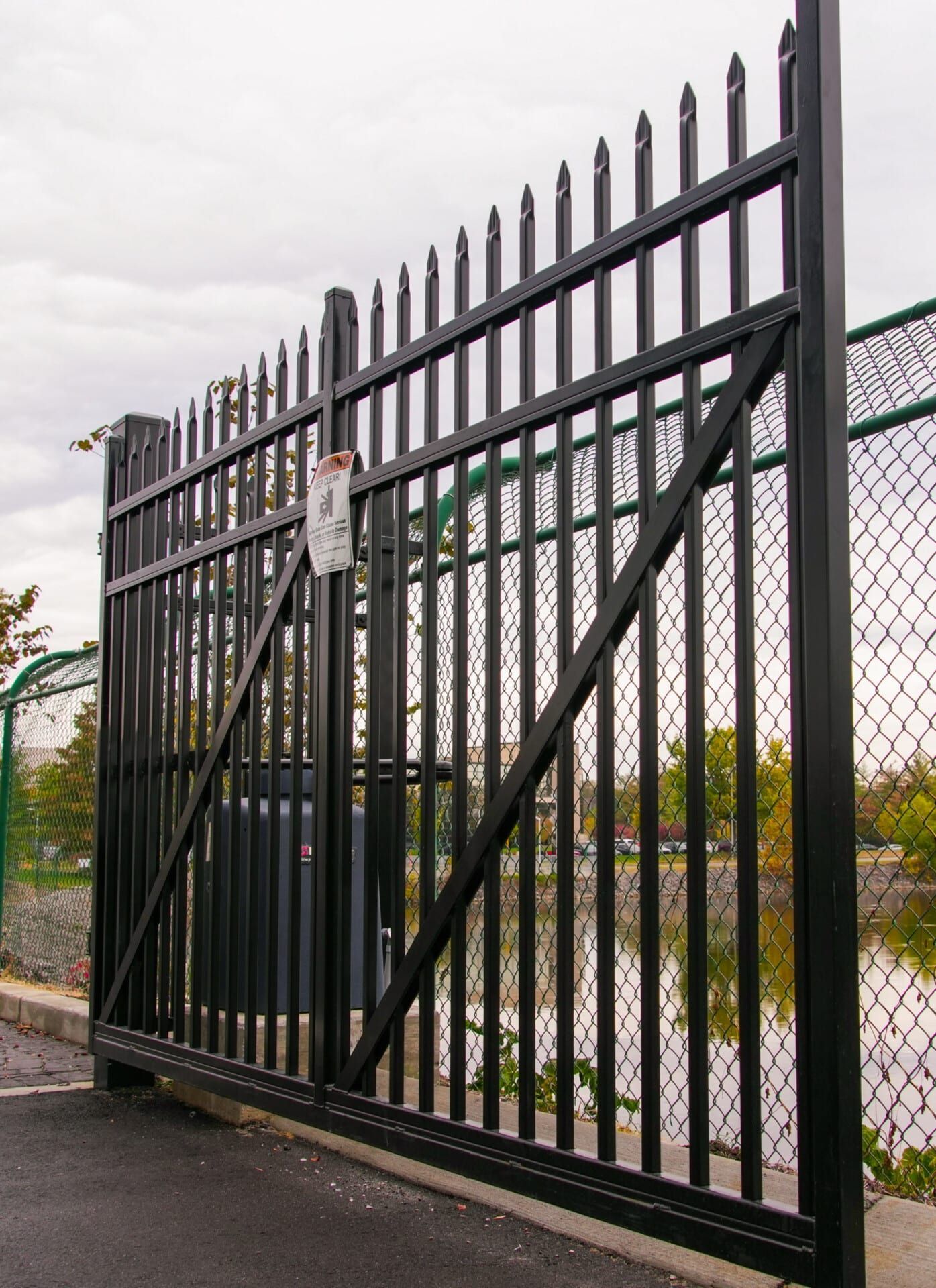 A black fence with a sign on it that says