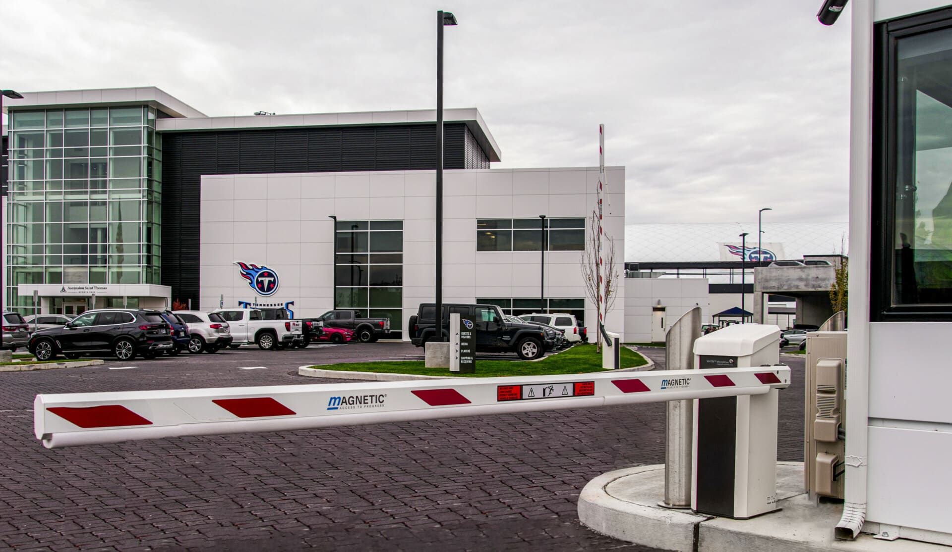 A parking lot with a barrier in front of a building.