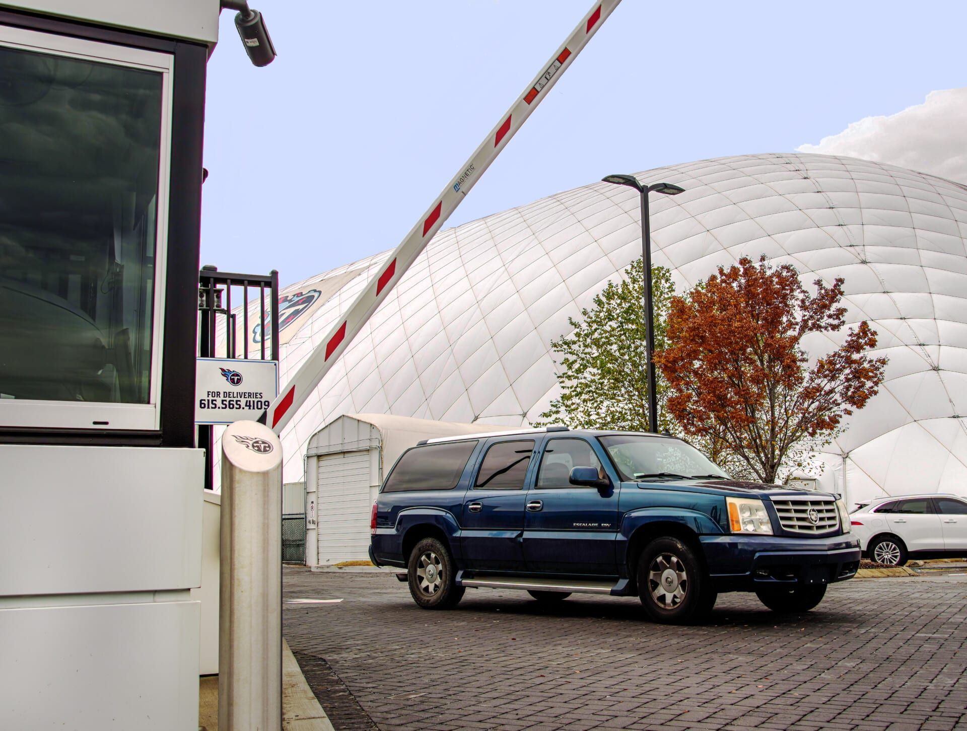 A blue suv is parked in front of a white building
