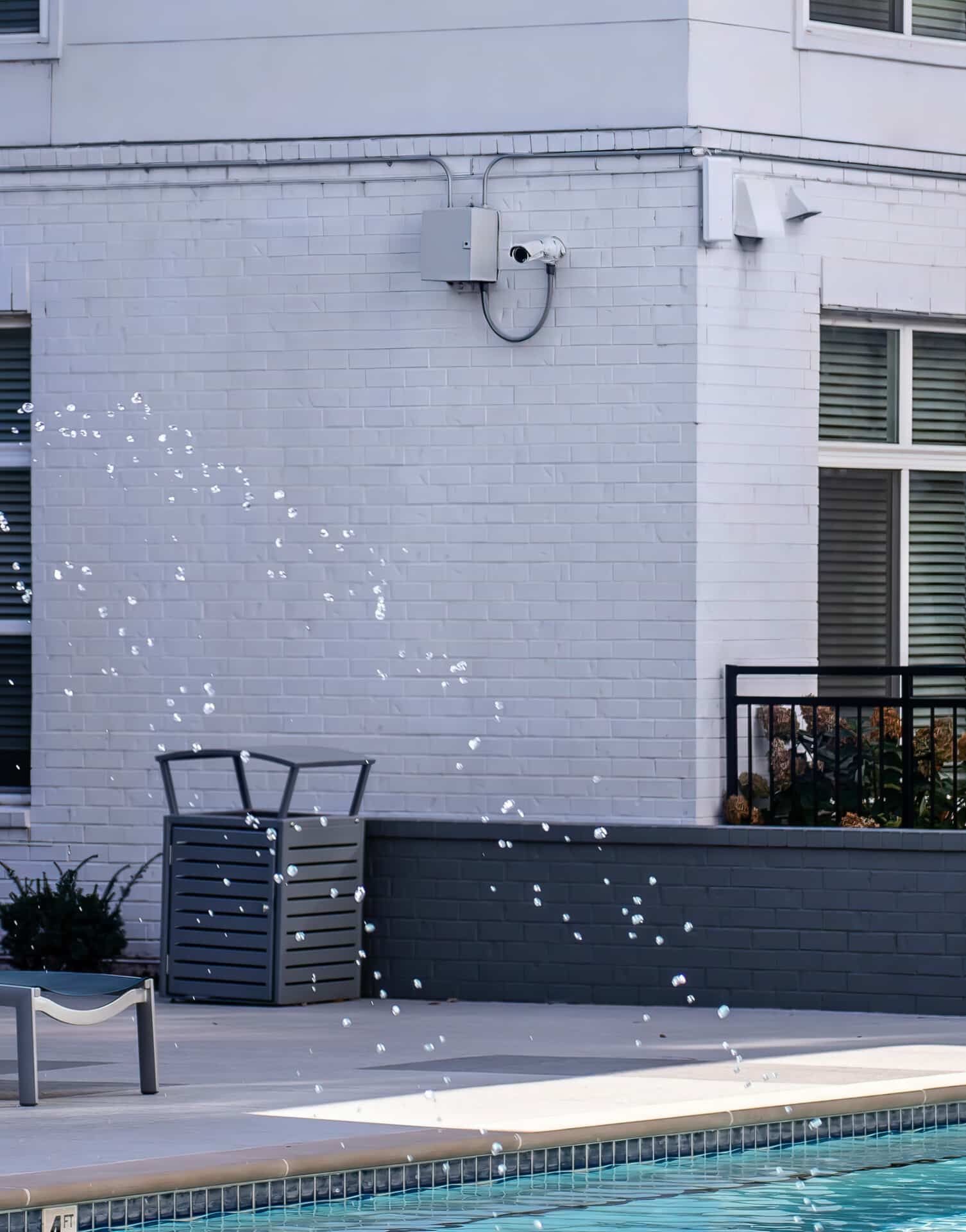 A swimming pool with a white building in the background