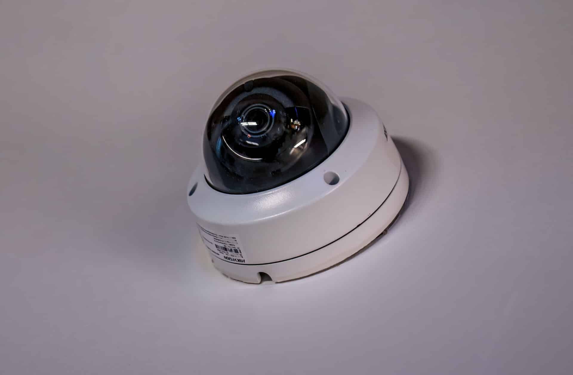 A dome camera is sitting on a white surface.