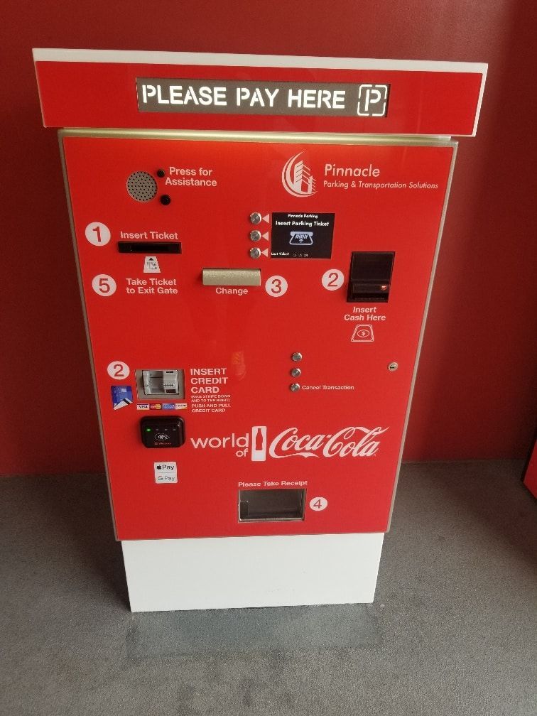 A red coca cola machine that says please pay here