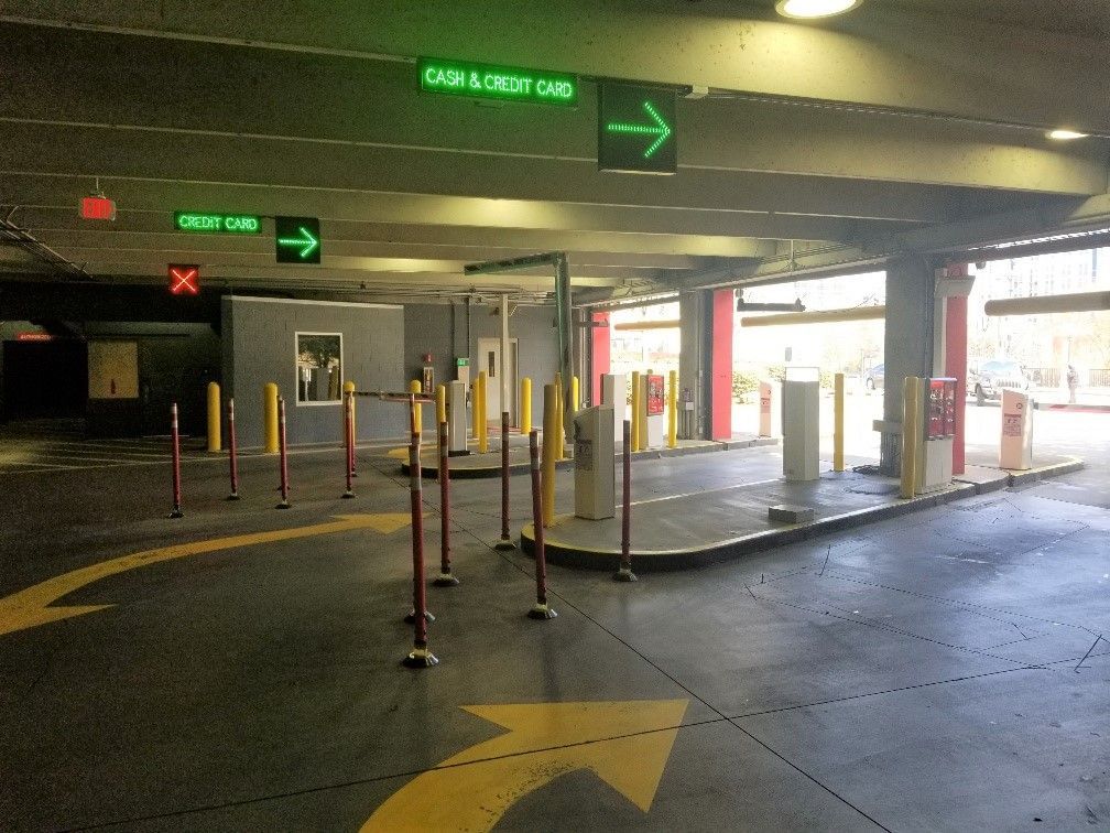 A parking garage with a green sign that says cash & credit card