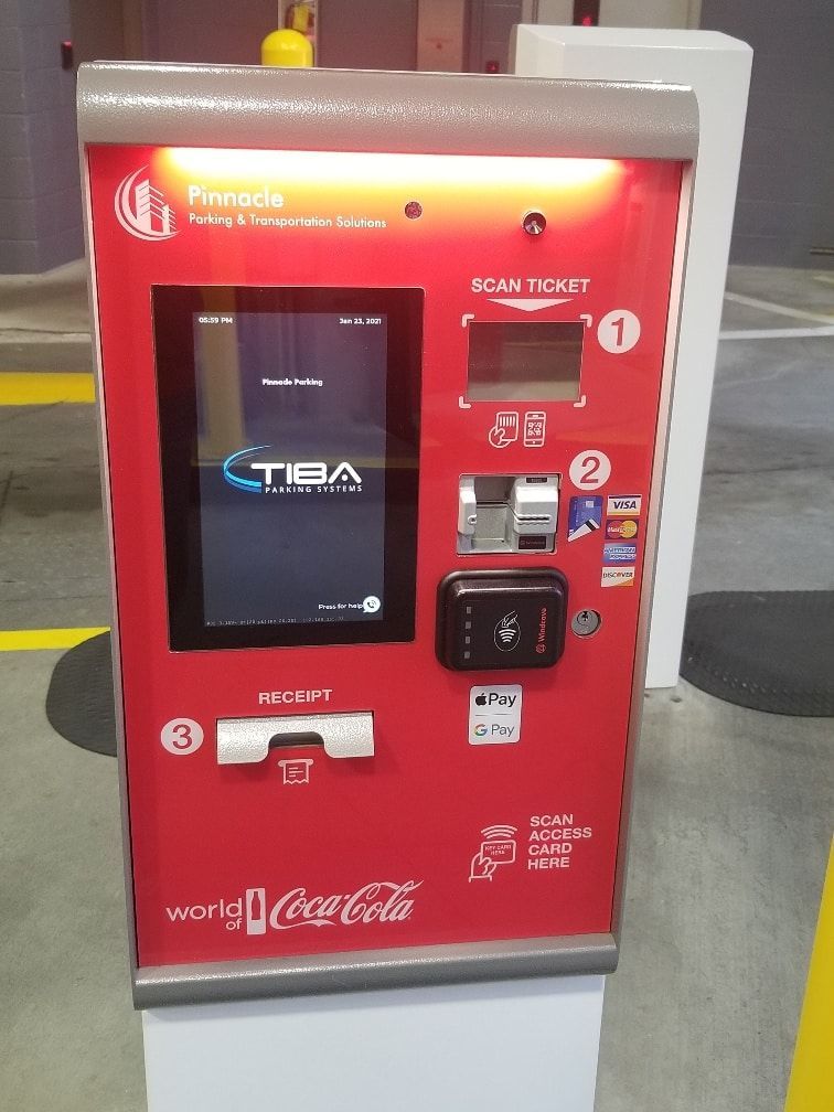 A red coca cola vending machine in a parking lot