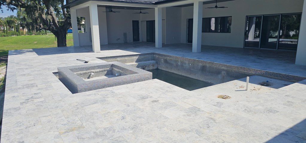 Empty concrete courtyard with a raised square fire pit under a shaded pavilion