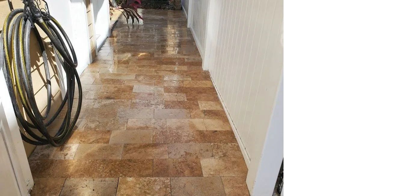 Narrow hallway with brown tile floor, white walls, and coiled hoses on the left