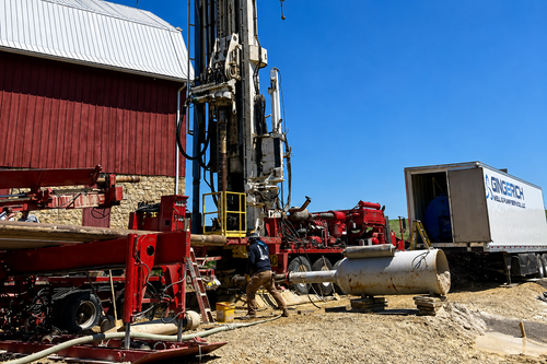 Blue industrial pipes and pumps connected to large machinery in a utility plant setting