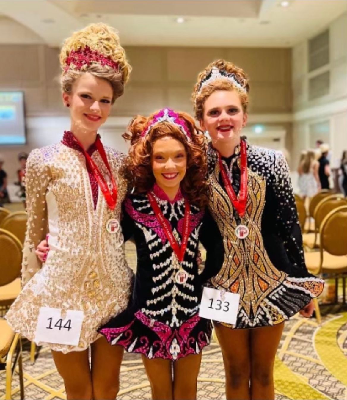 Young girls dressed in dance outfits each wearing a medal