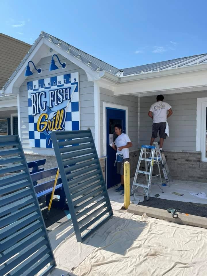 Two men are painting the outside of a building.
