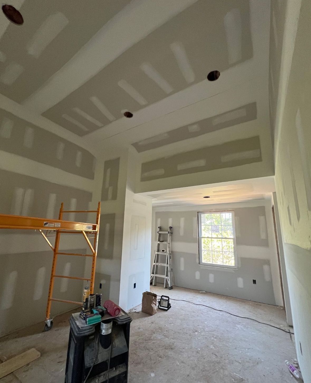 Drywall sheets secured to wall framing during construction