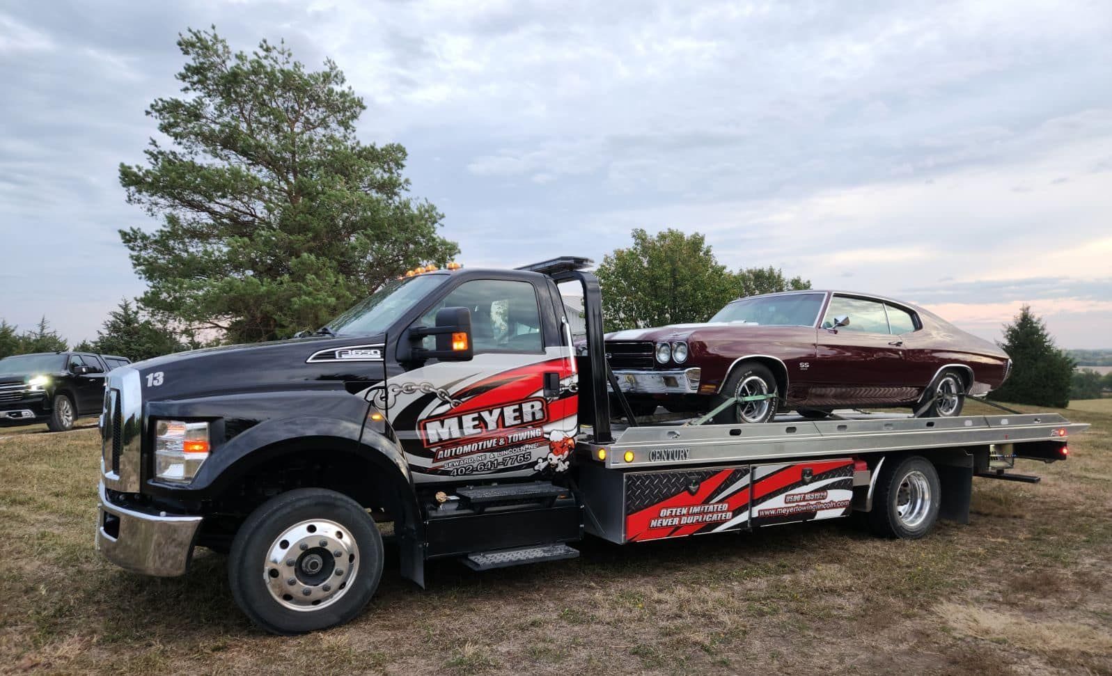 A tow truck is carrying a car on the back of it