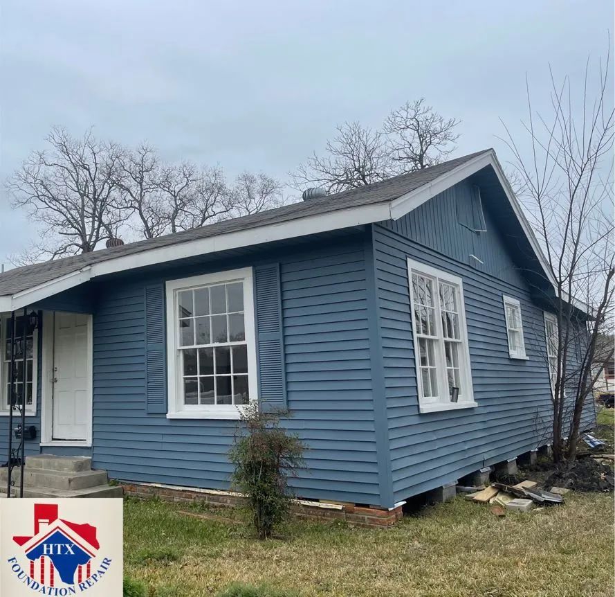 Blue single-story house with white trim and a front porch under a cloudy sky