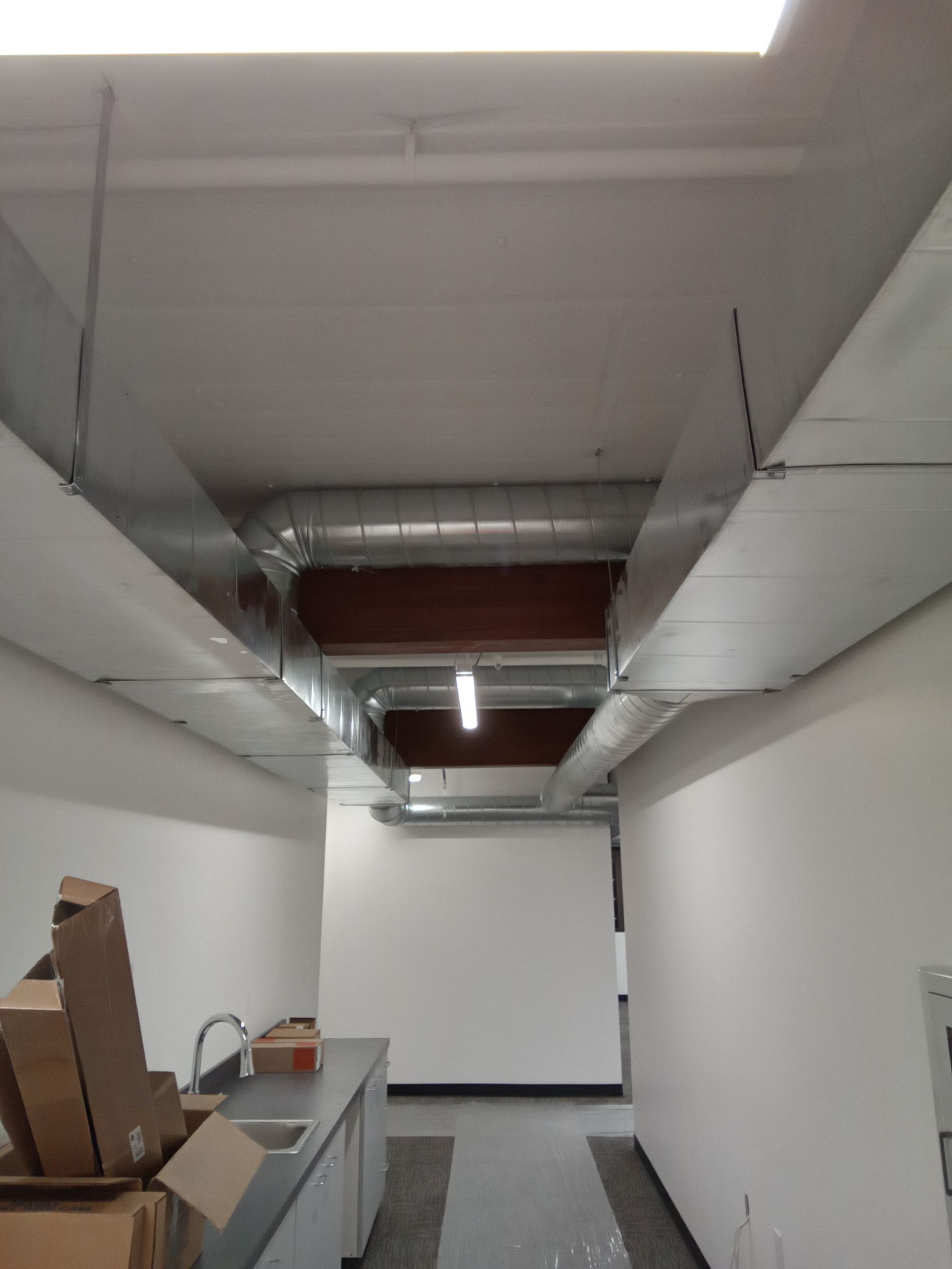 A kitchen with a sink and boxes on the counter