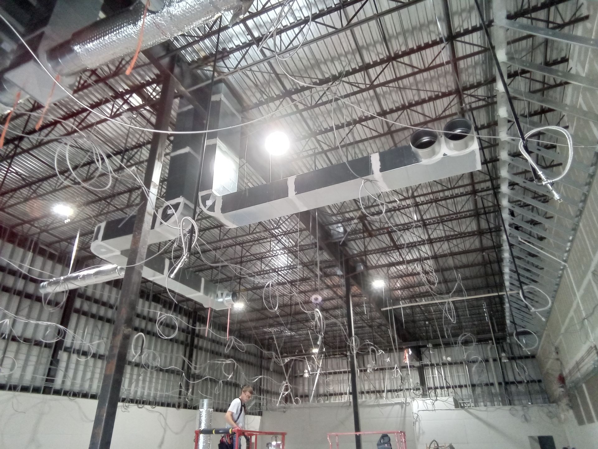 A large warehouse with a lot of wires hanging from the ceiling