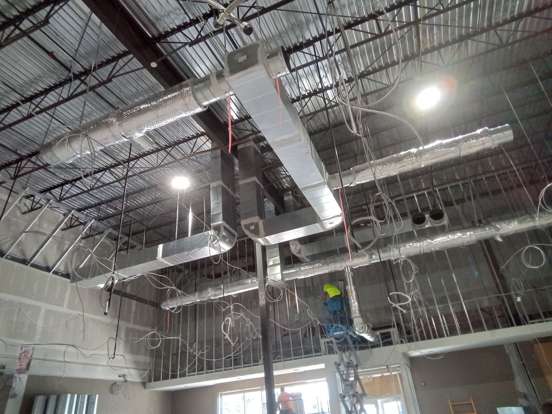 A man is standing on a ladder in a building under construction