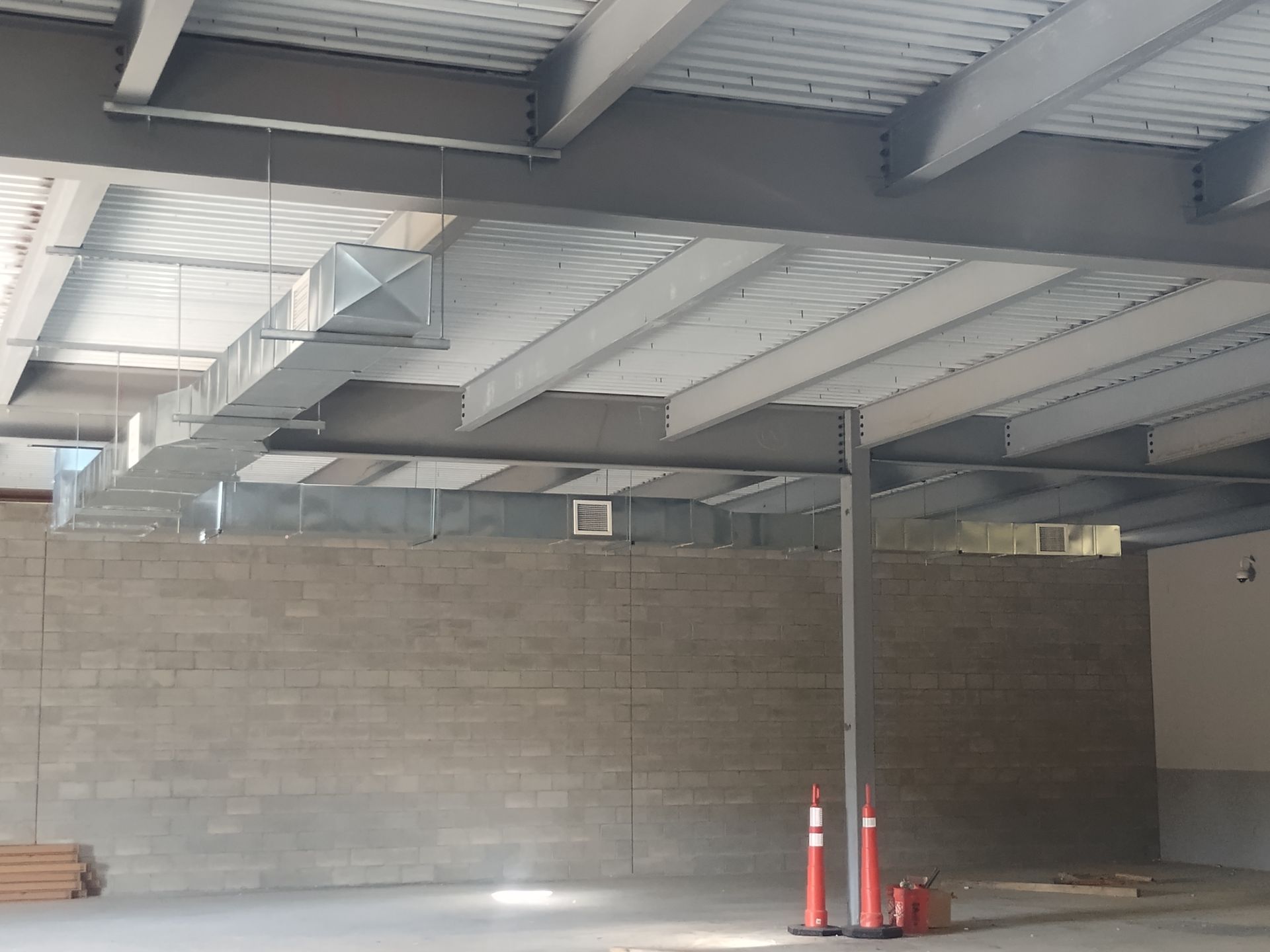 A large empty room with a brick wall and a metal ceiling