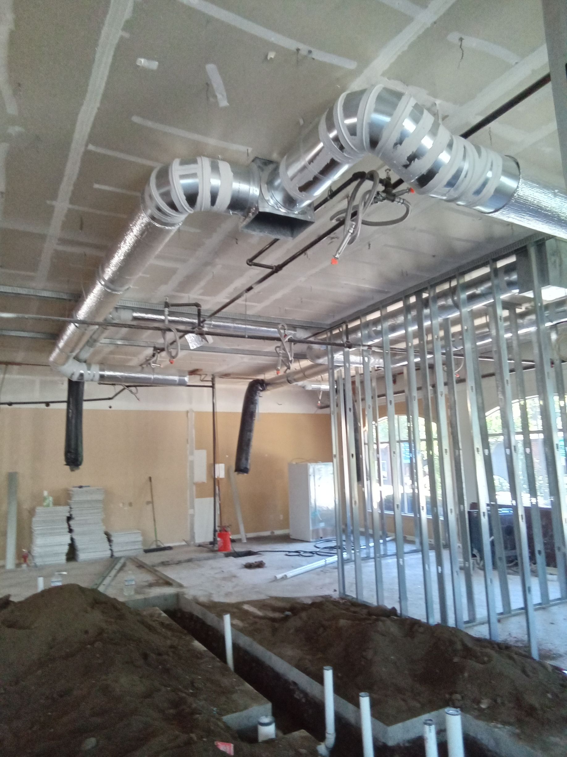 A building under construction with pipes coming out of the ceiling