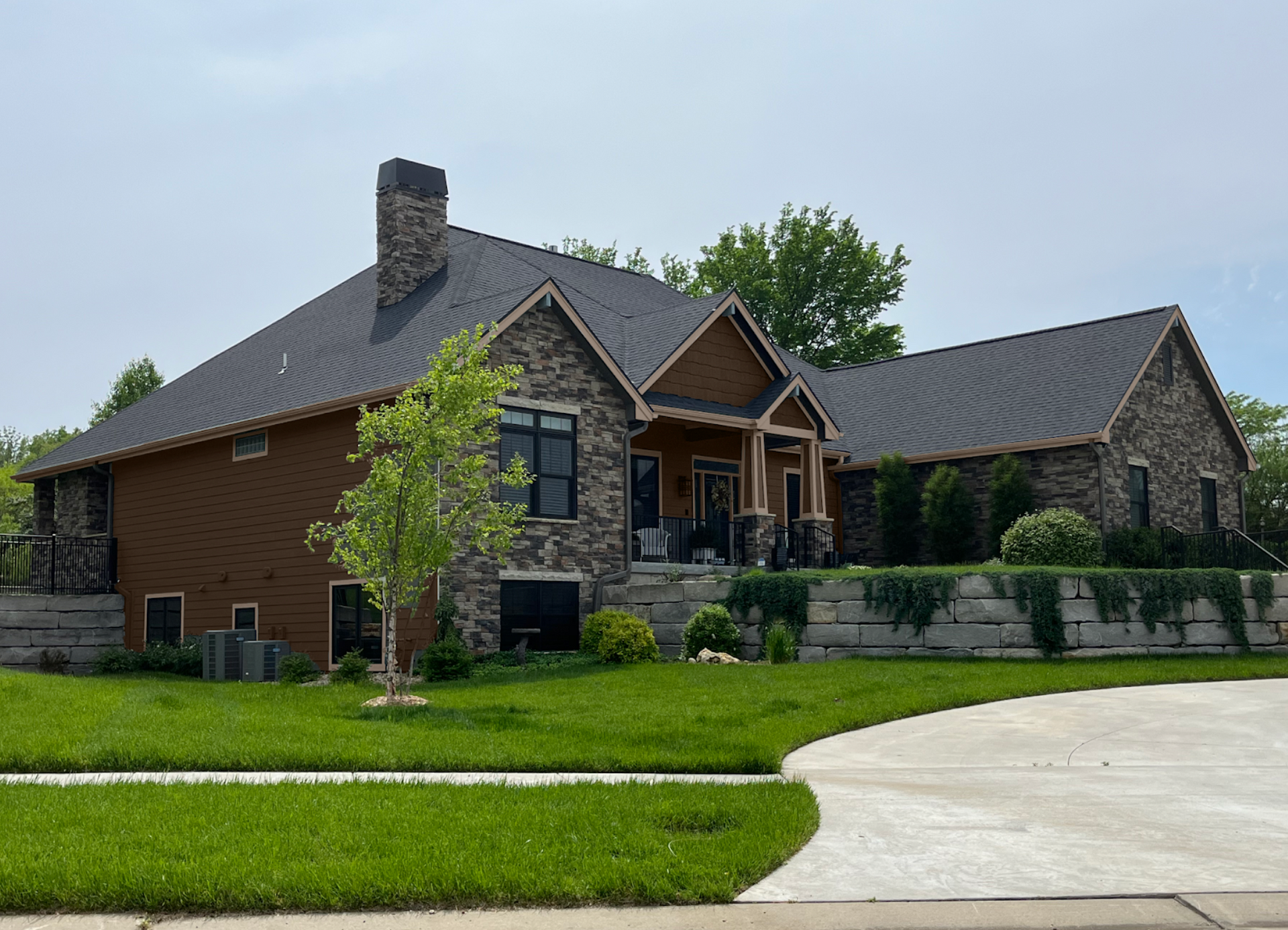 A large brick and stone house with a black roof