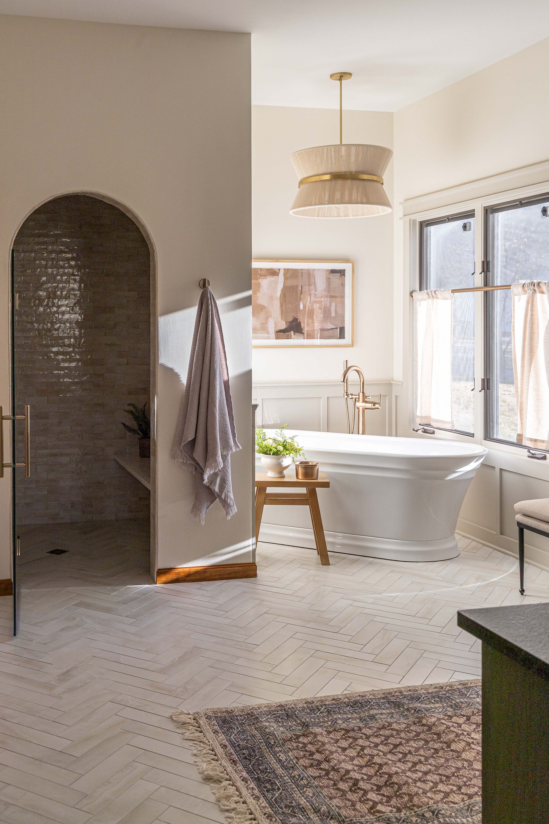 A bathroom with a tub, shower, and rug.