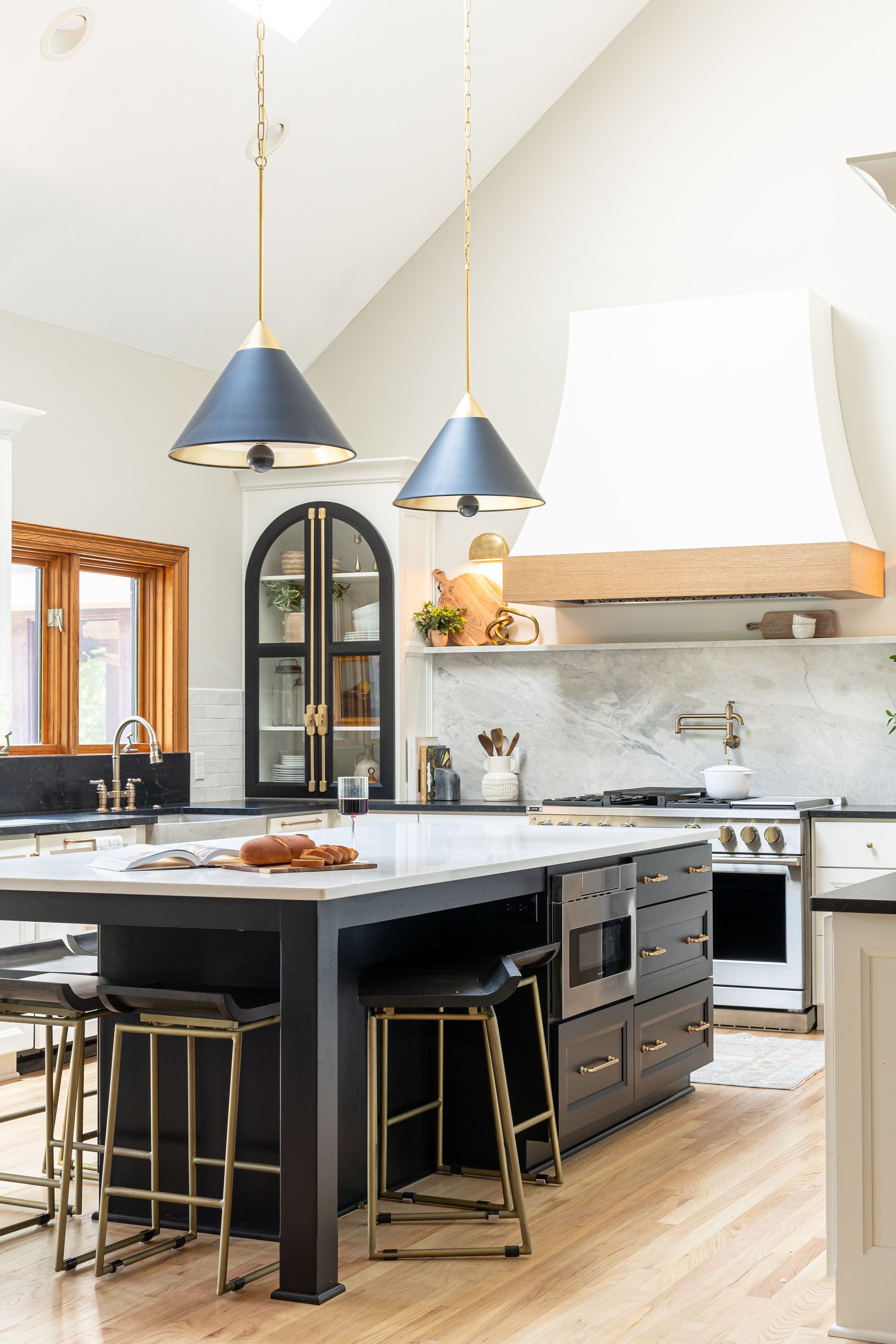 A kitchen with a large island and stools.