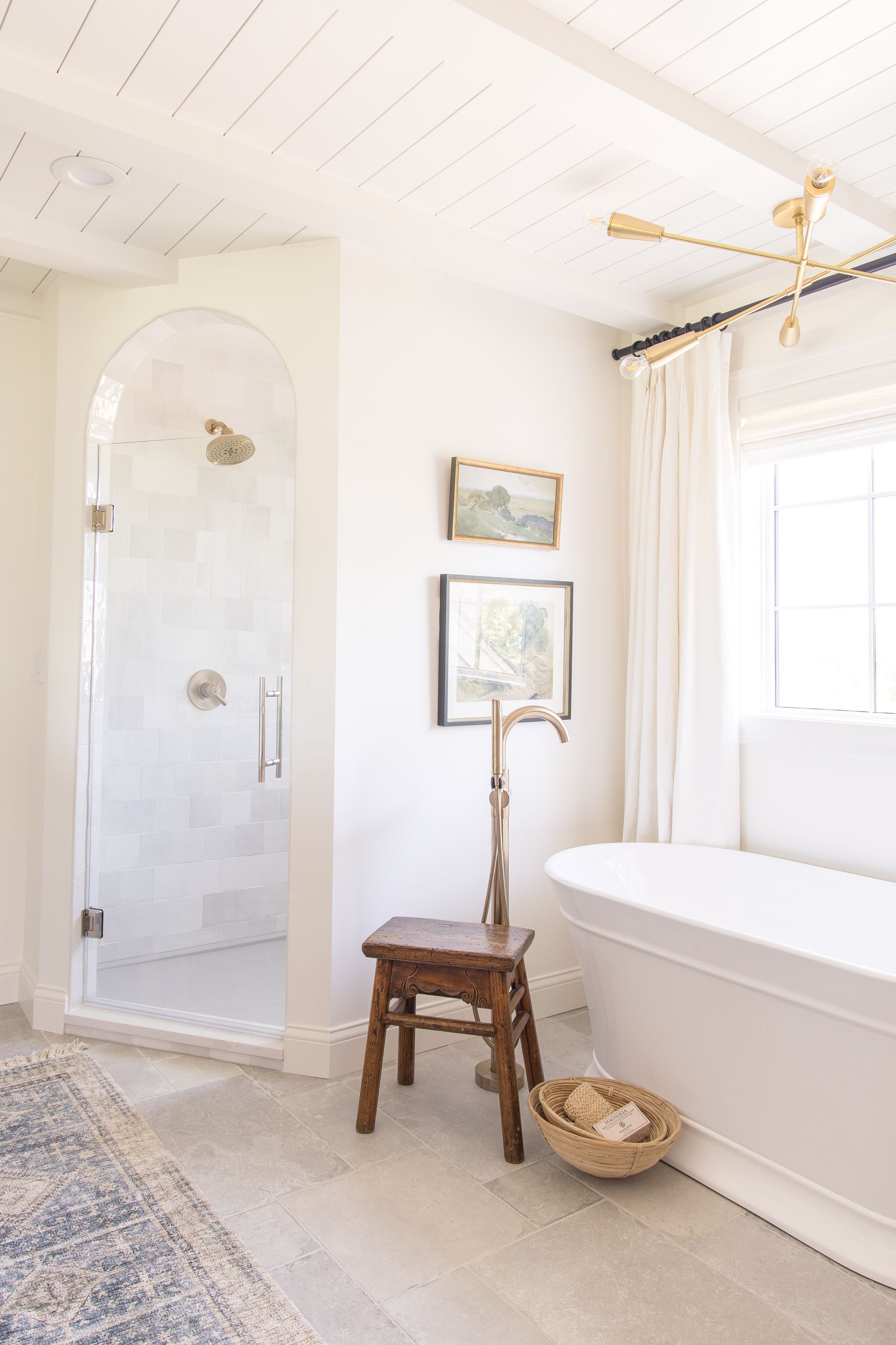 A bathroom with a tub, shower, and stool.