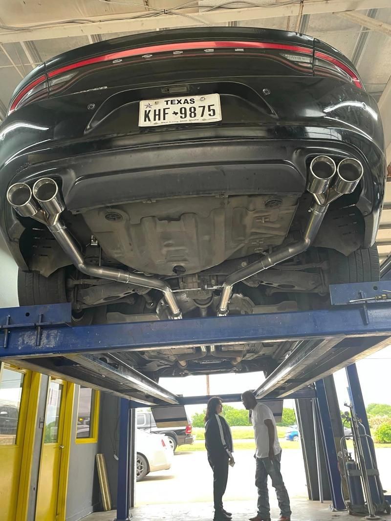 A car is sitting on top of a lift in a garage.