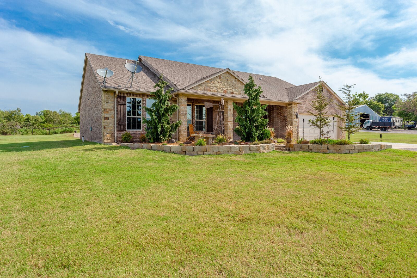 A large house is sitting on top of a lush green field.