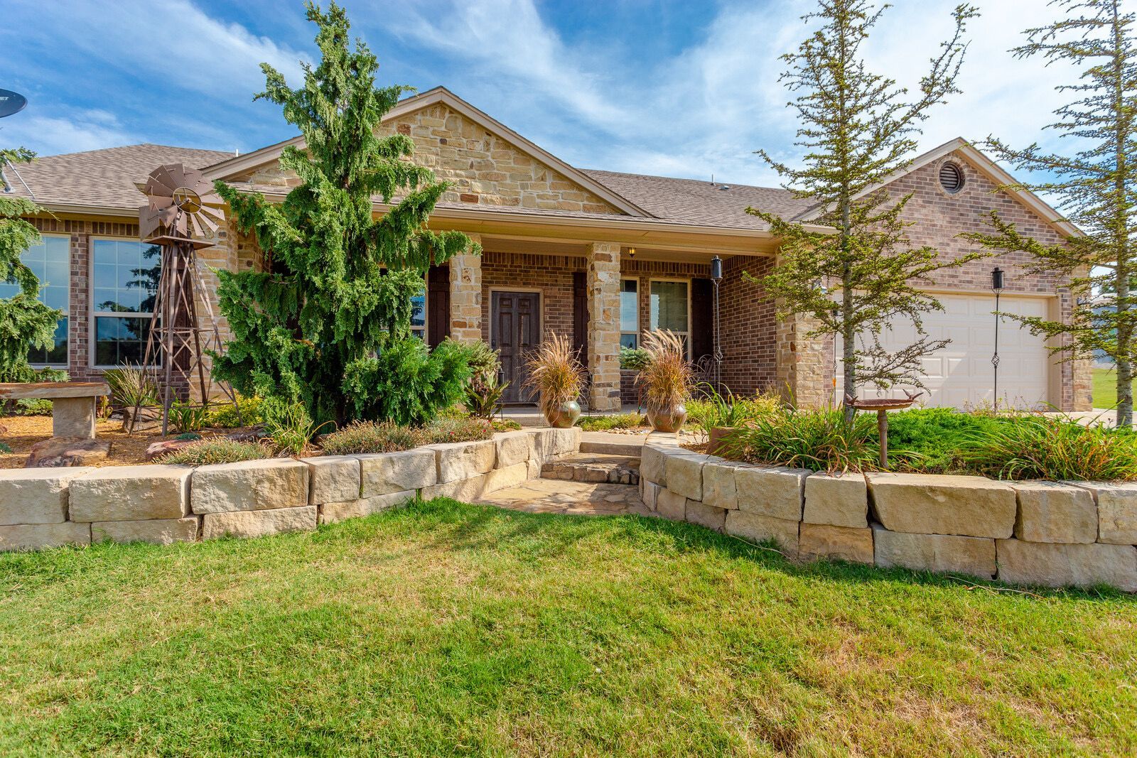 A large brick house with a large lawn in front of it.