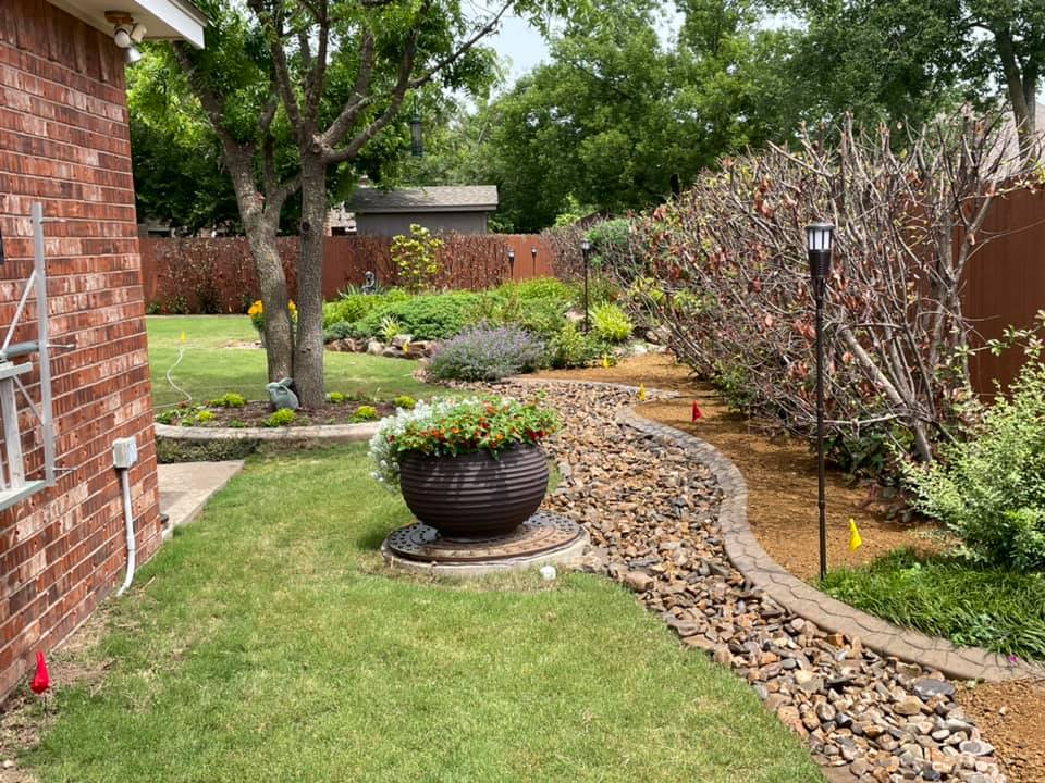 A brick house with a lush green lawn and a stone walkway leading to it.