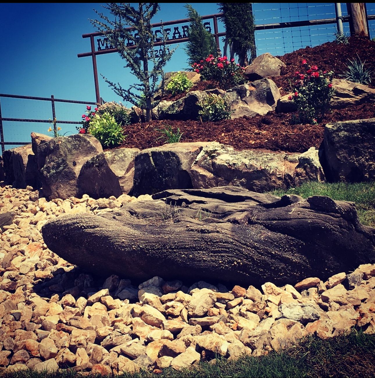 A large rock sits in front of a sign that says mountain
