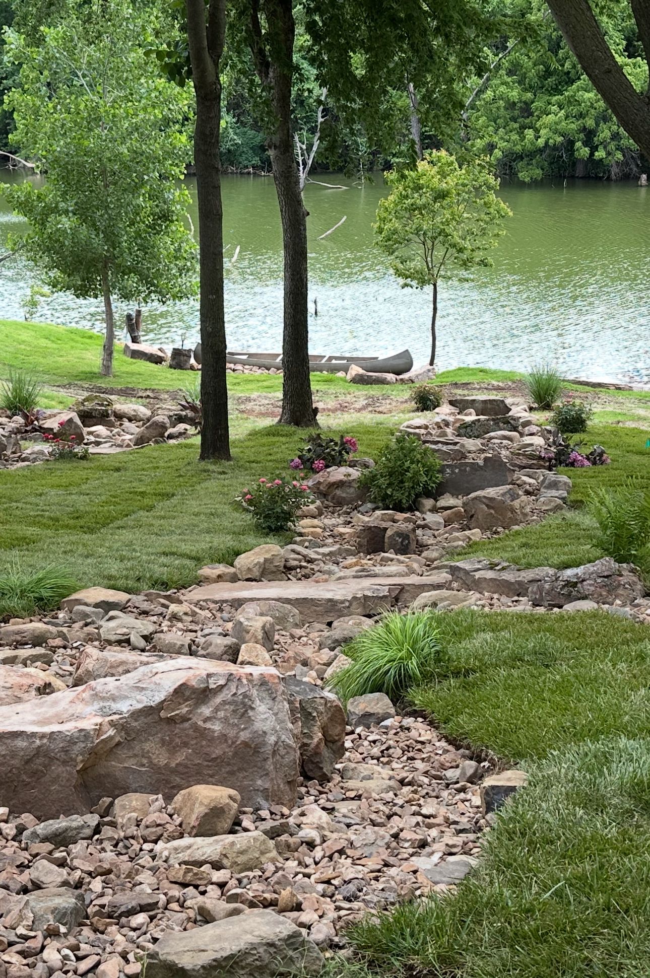 There is a river in the background and a lot of rocks in the foreground.